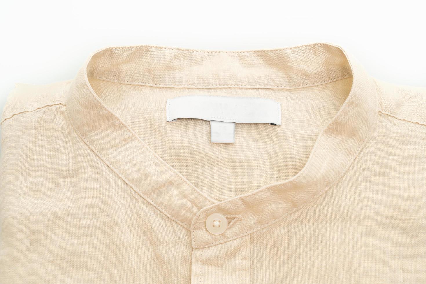 camisa bege dobrada isolada no fundo branco foto