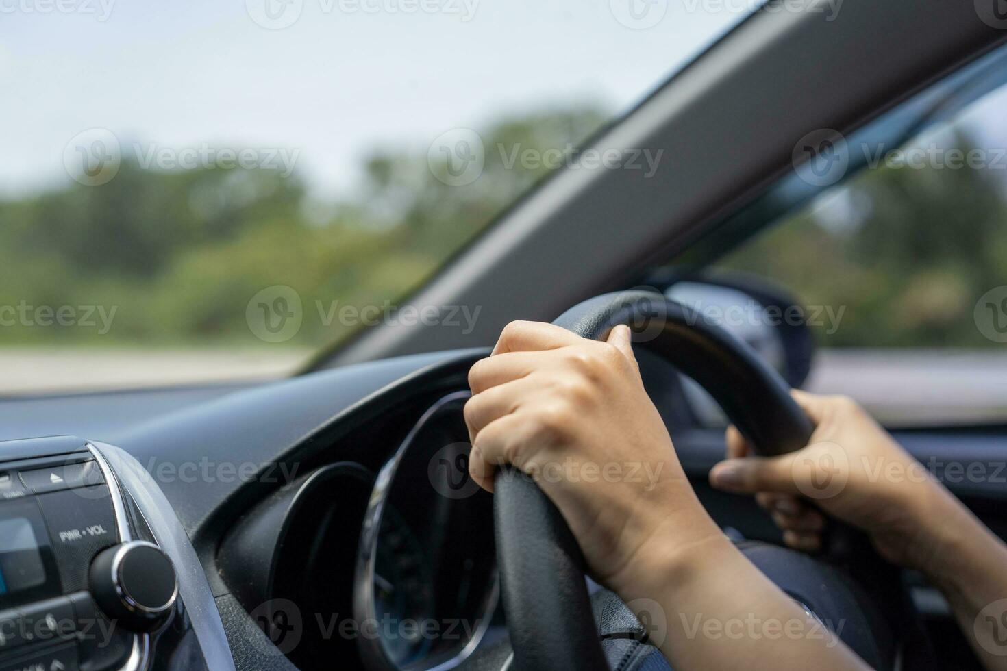 fêmea mãos em a carro direção roda fechar acima. mulher é dirigindo uma carro. foto