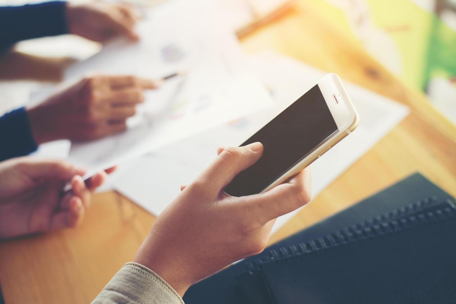 mão de mulher de negócios trabalhando em telefone inteligente e laptop foto