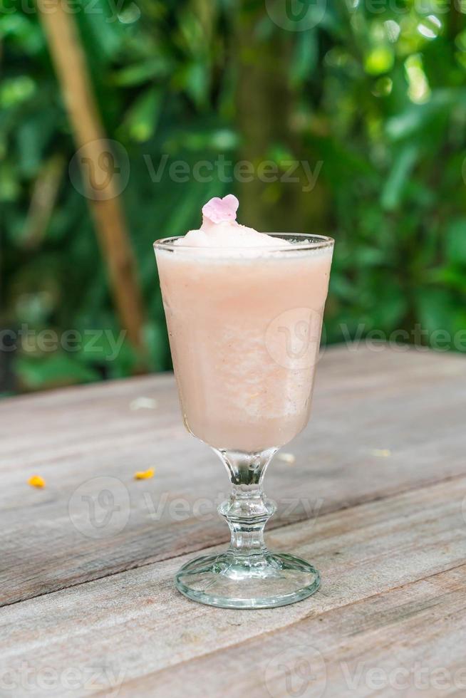 lichia com suco de rosa na mesa de madeira foto