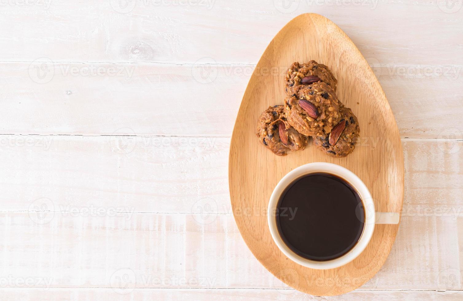 café preto com biscoitos na madeira foto