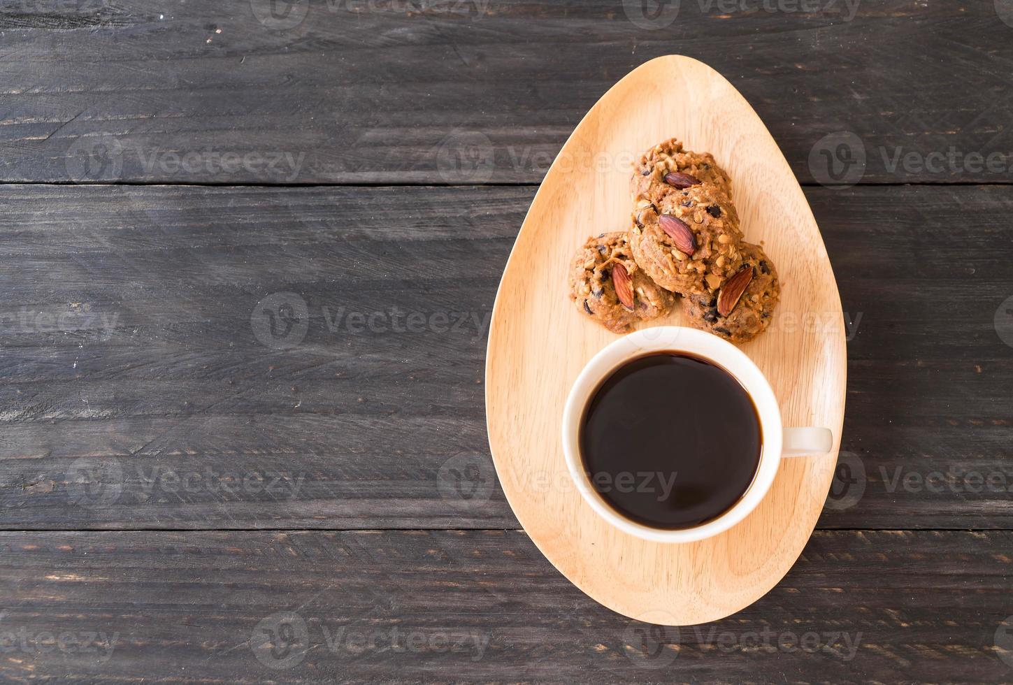 café preto com biscoitos na madeira foto
