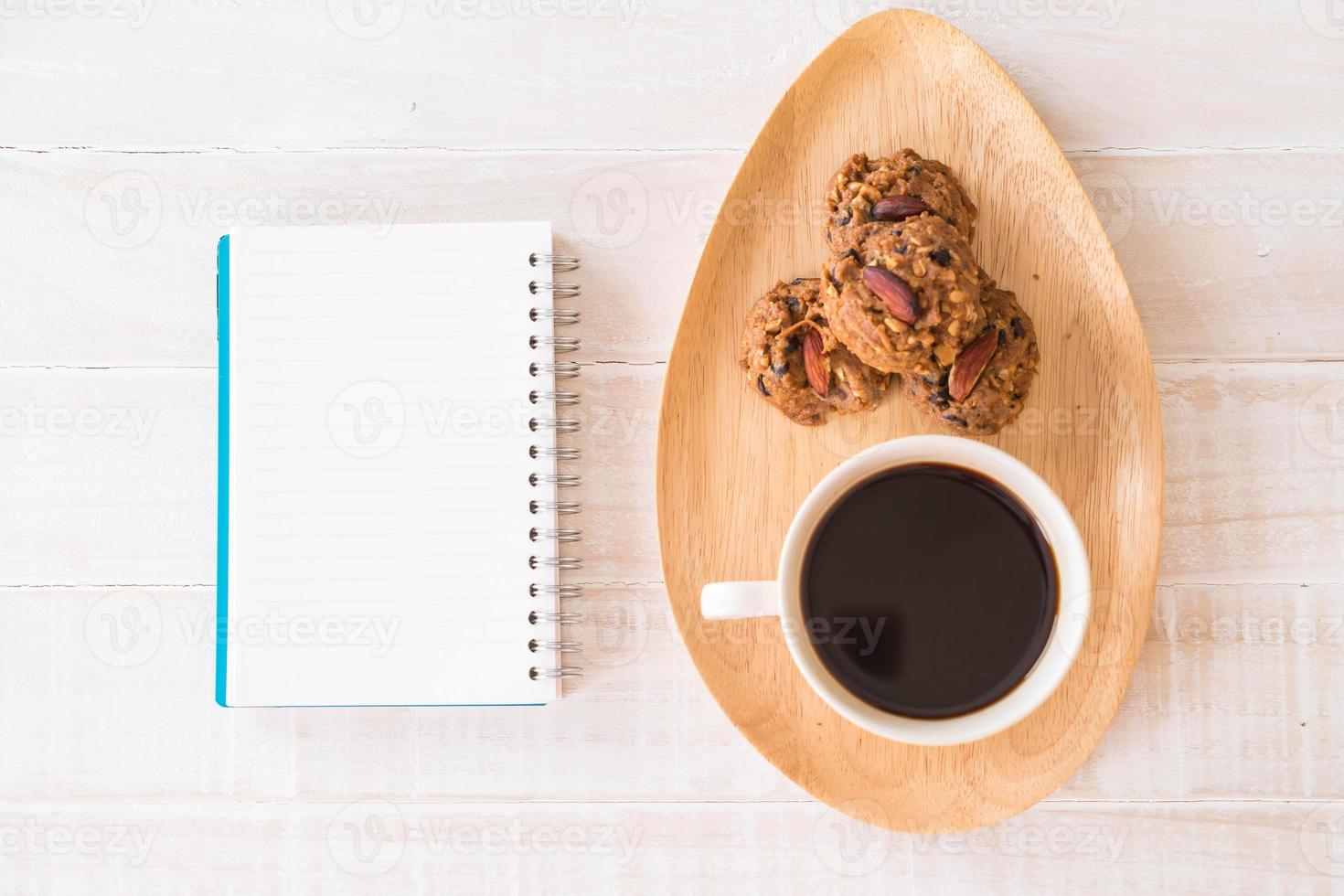 café preto e biscoitos com notebook na mesa foto