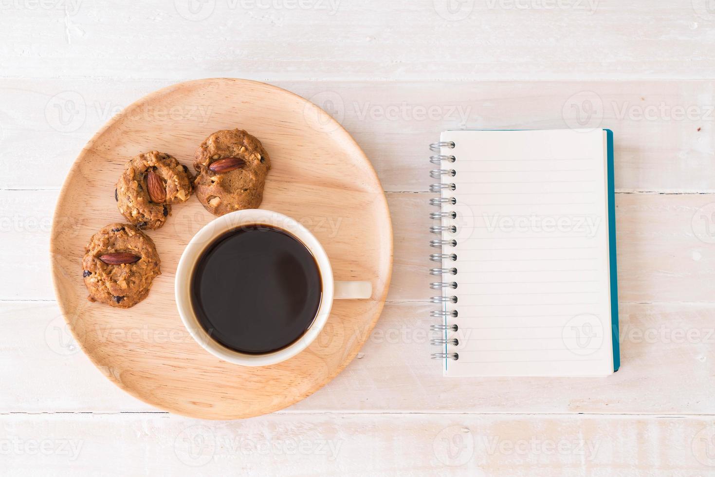 café preto e biscoitos com notebook na mesa foto