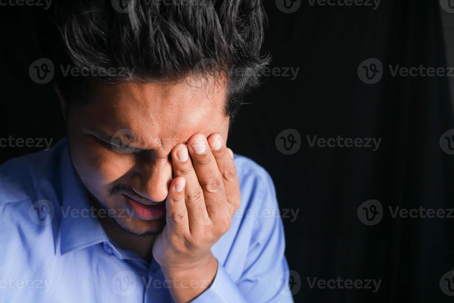 close-up de um homem chateado sofrendo de fortes dores nos olhos foto