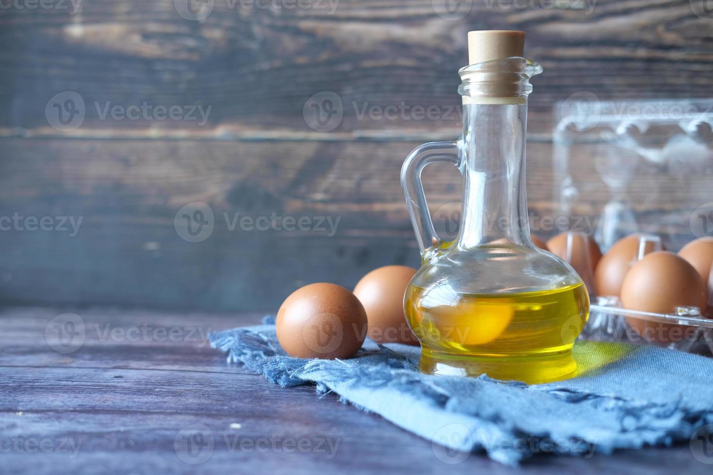 close-up de ovos em uma tigela e óleo de cozinha na mesa foto