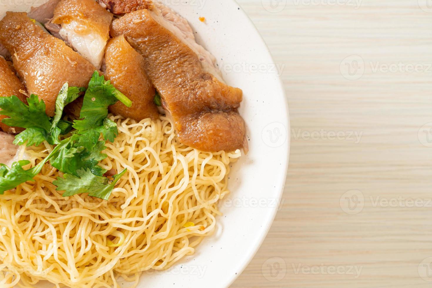 Tigela de macarrão com perna de porco estufada seca - comida asiática foto