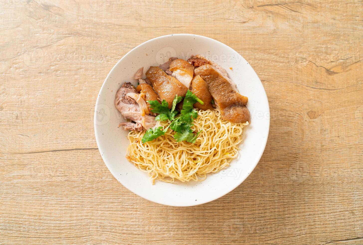 Tigela de macarrão com perna de porco estufada seca - comida asiática foto