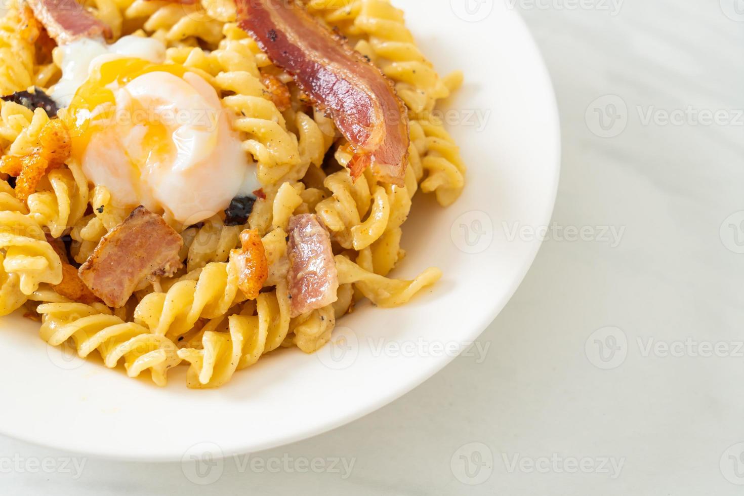 Bacon picante de macarrão fusilli carbonara - comida italiana foto