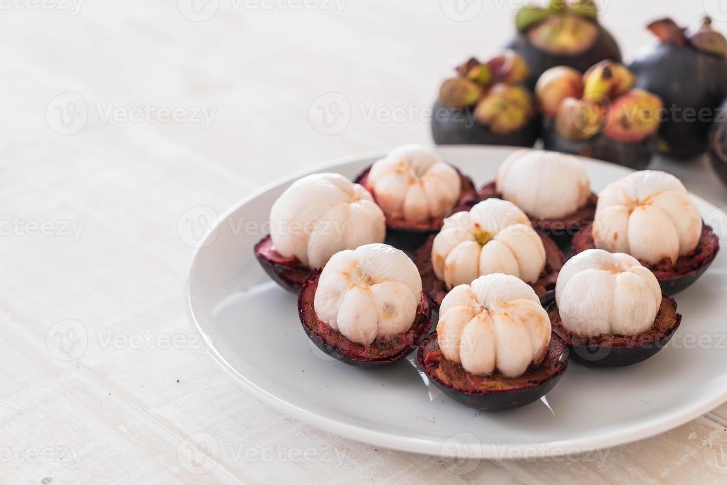 mangostão fresco na mesa de madeira foto