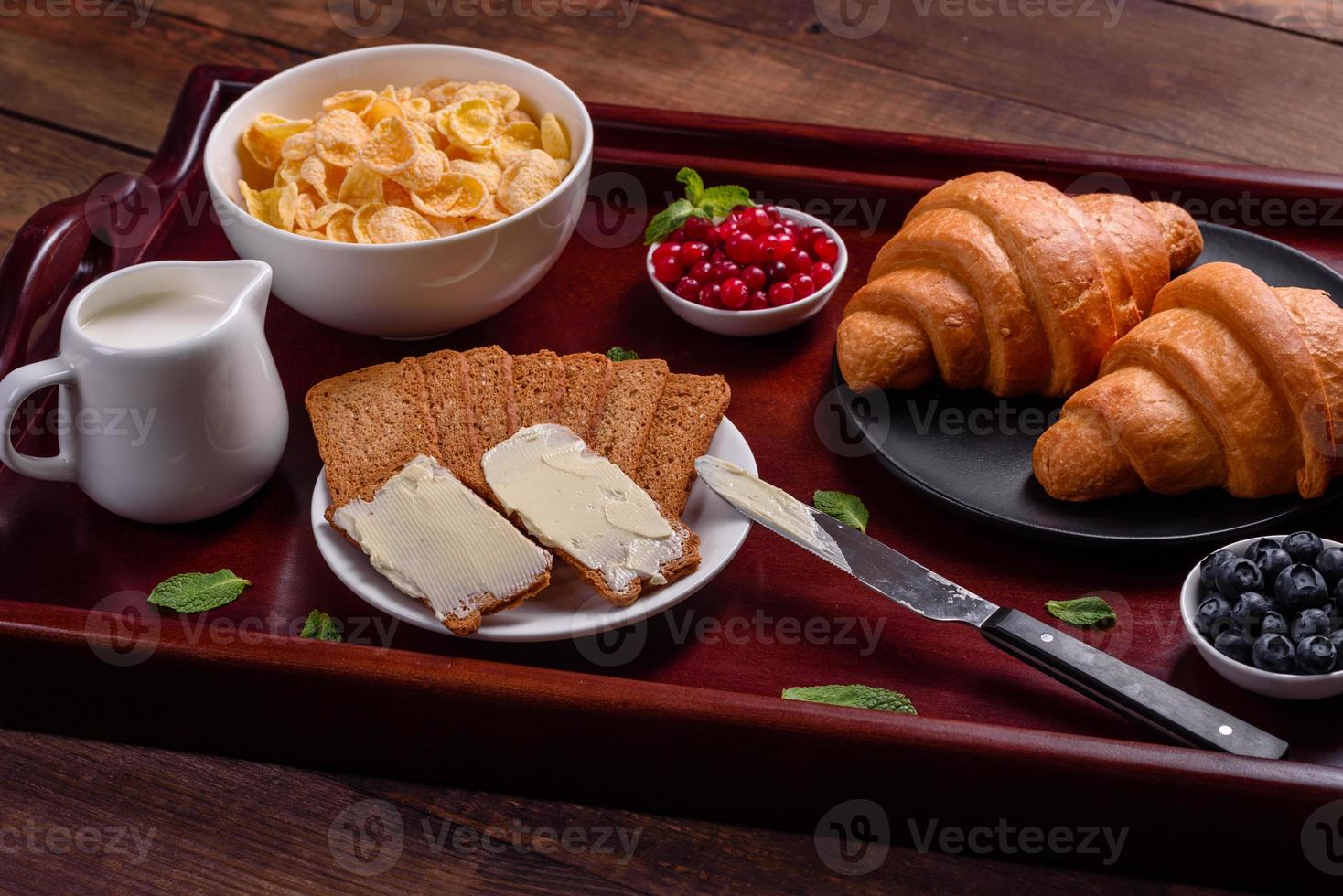 delicioso café da manhã com croissants frescos e frutas vermelhas maduras foto