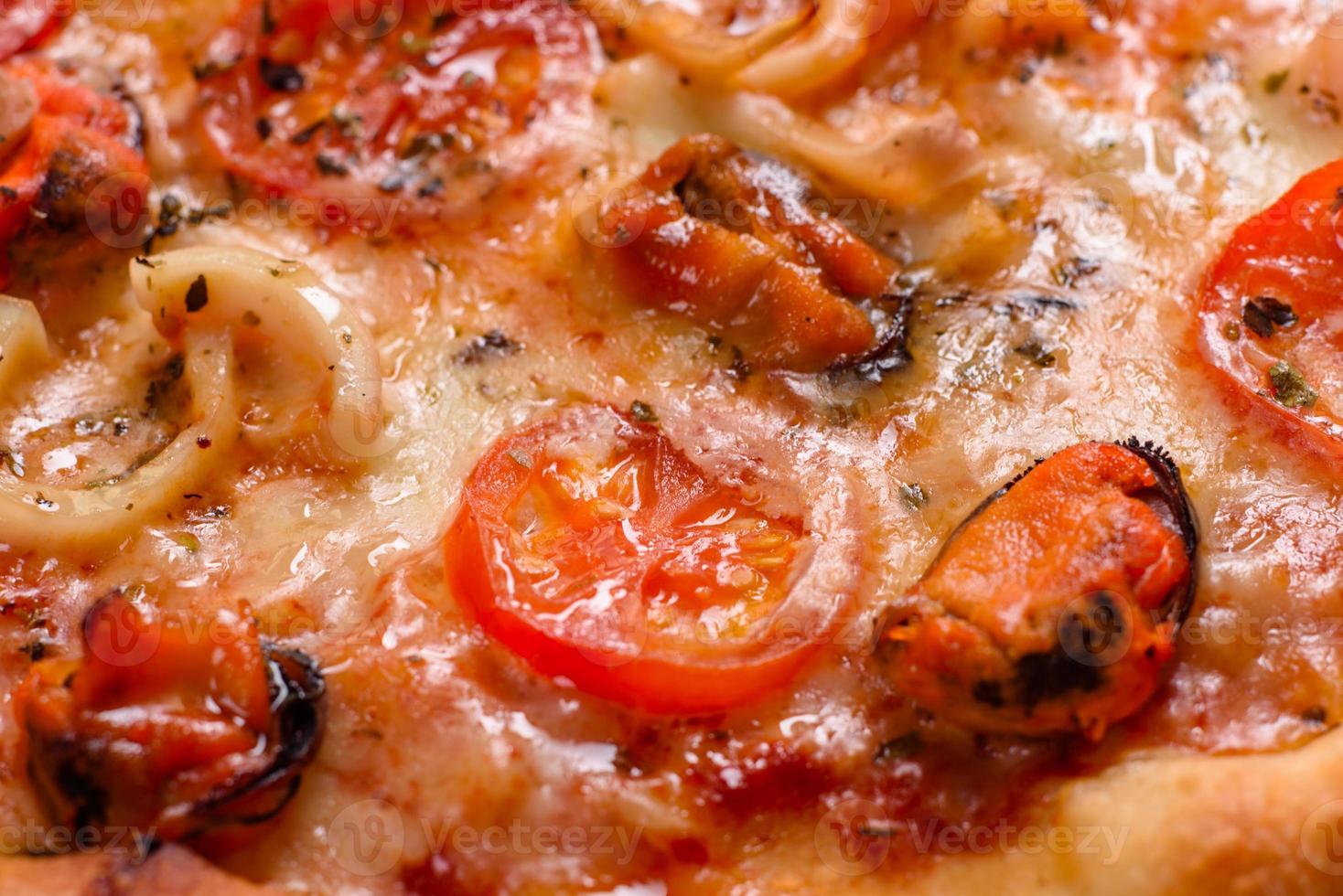 saborosa pizza fatiada com frutos do mar e tomate em um fundo de concreto foto