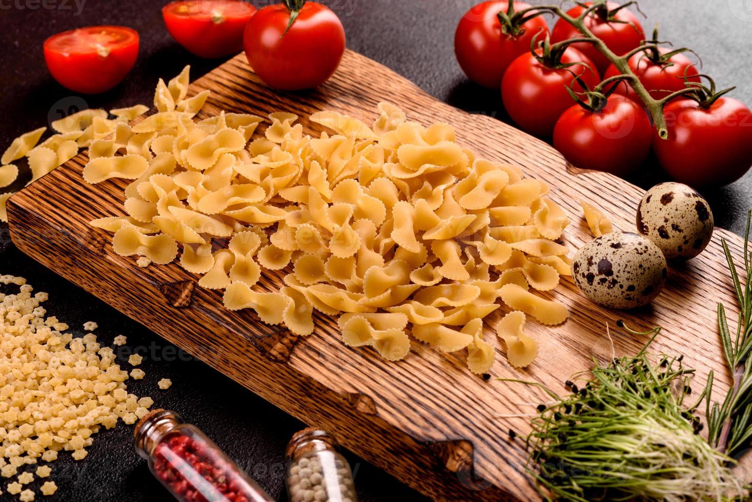 ingredientes para pasta de cozinha em um fundo escuro foto