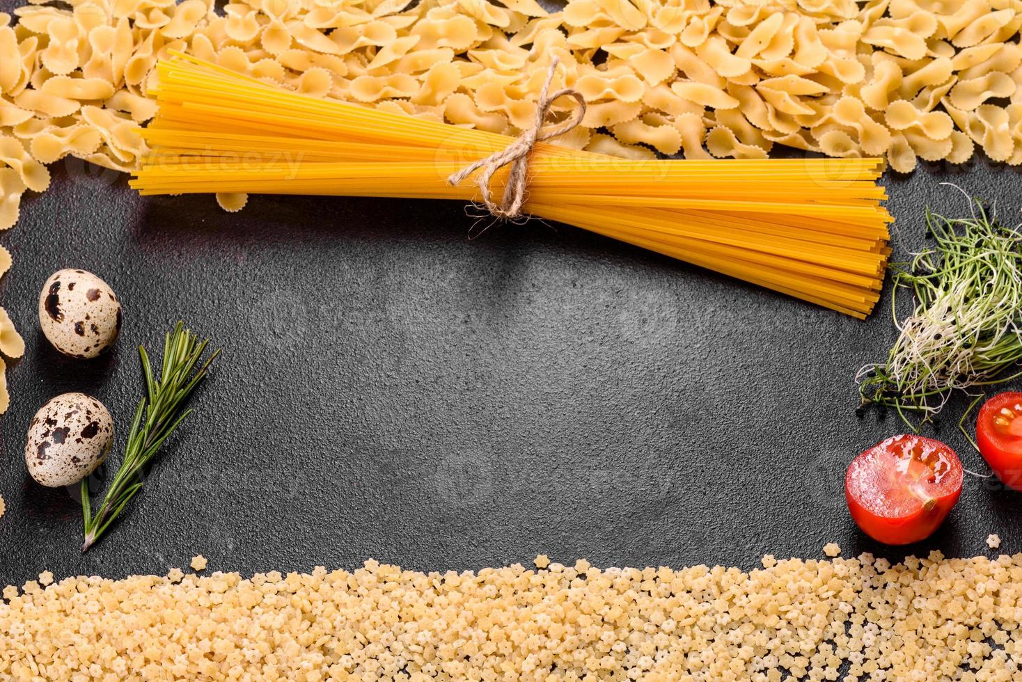 ingredientes para pasta de cozinha em um fundo escuro foto