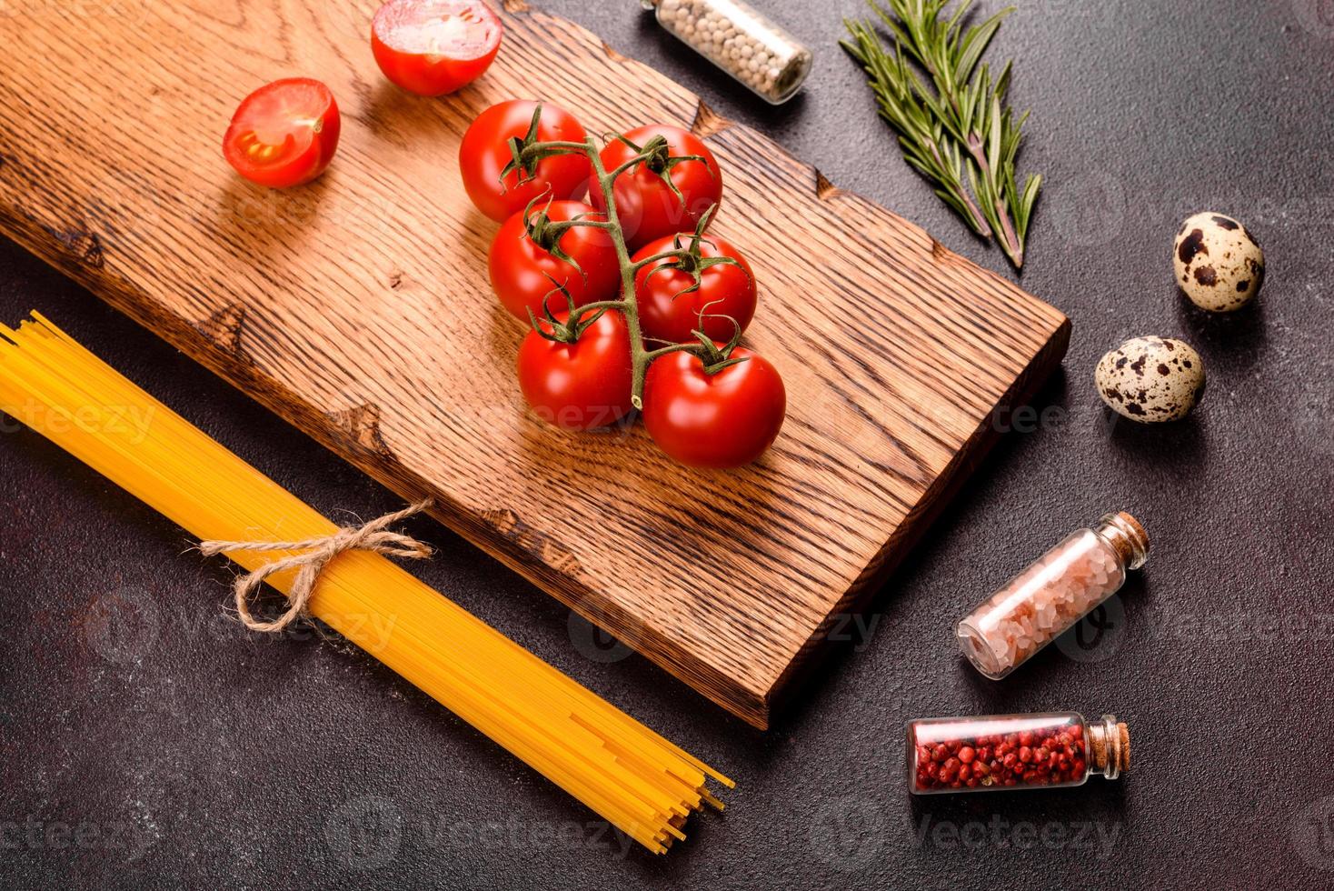 ingredientes para pasta de cozinha em um fundo escuro foto