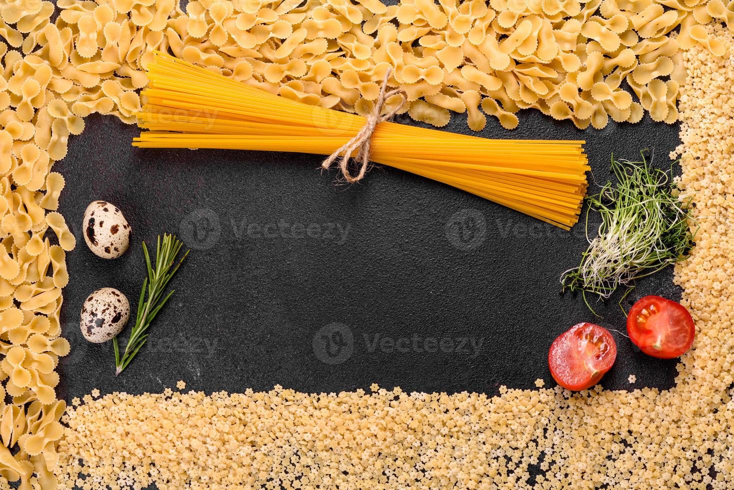 ingredientes para pasta de cozinha em um fundo escuro foto