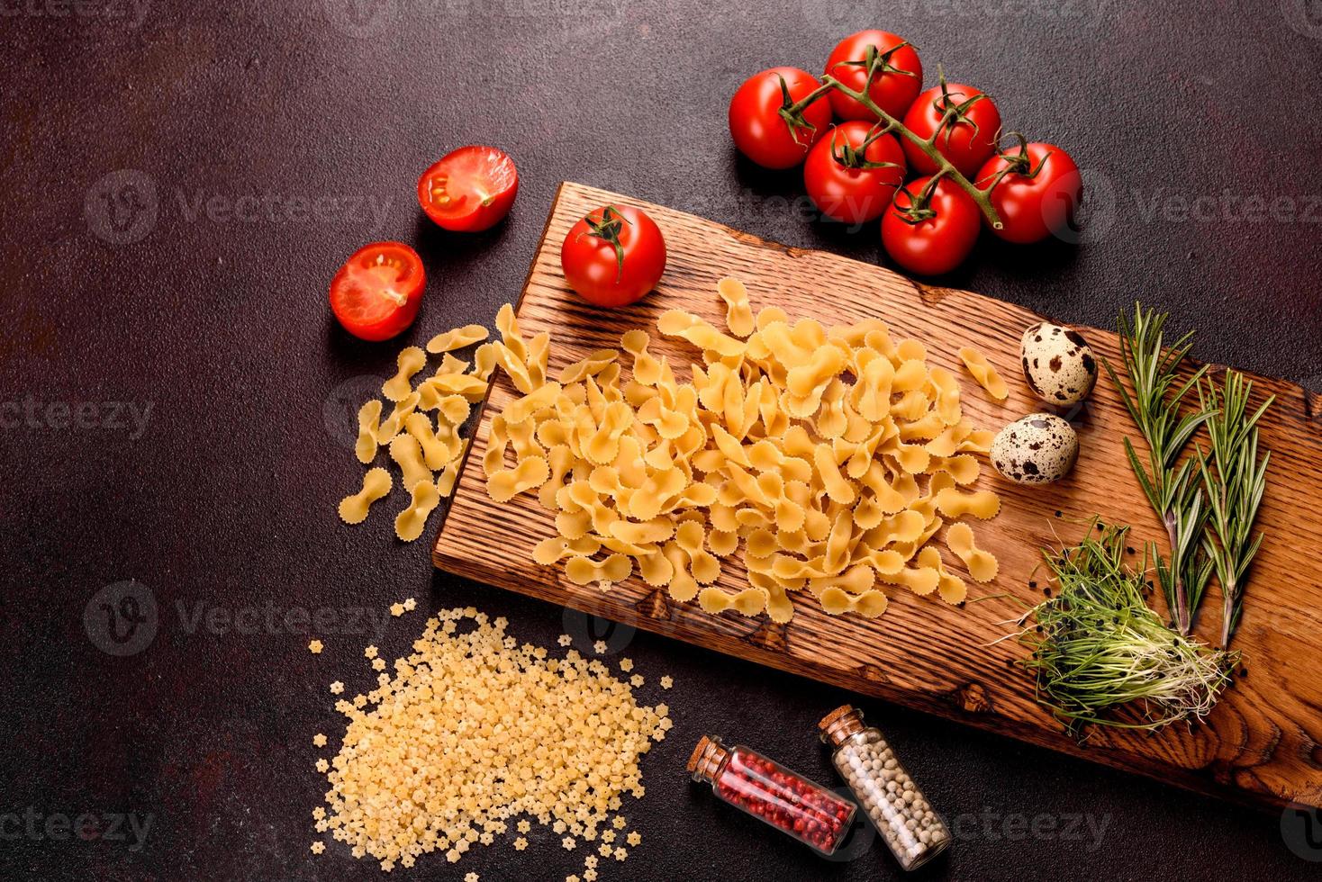 ingredientes para pasta de cozinha em um fundo escuro foto