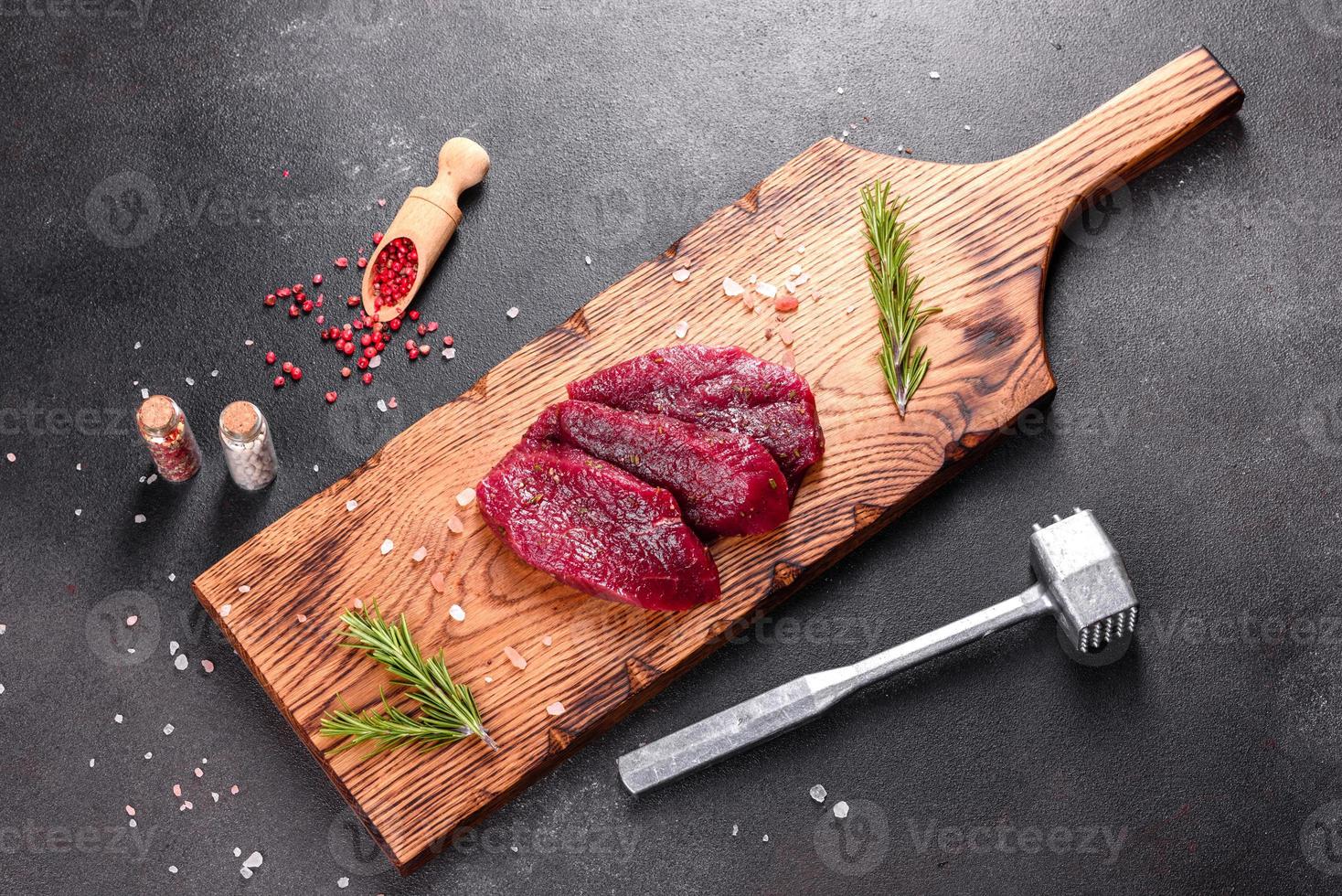 bife mignon de carne crua fresca, com sal, pimenta, tomilho, tomate foto