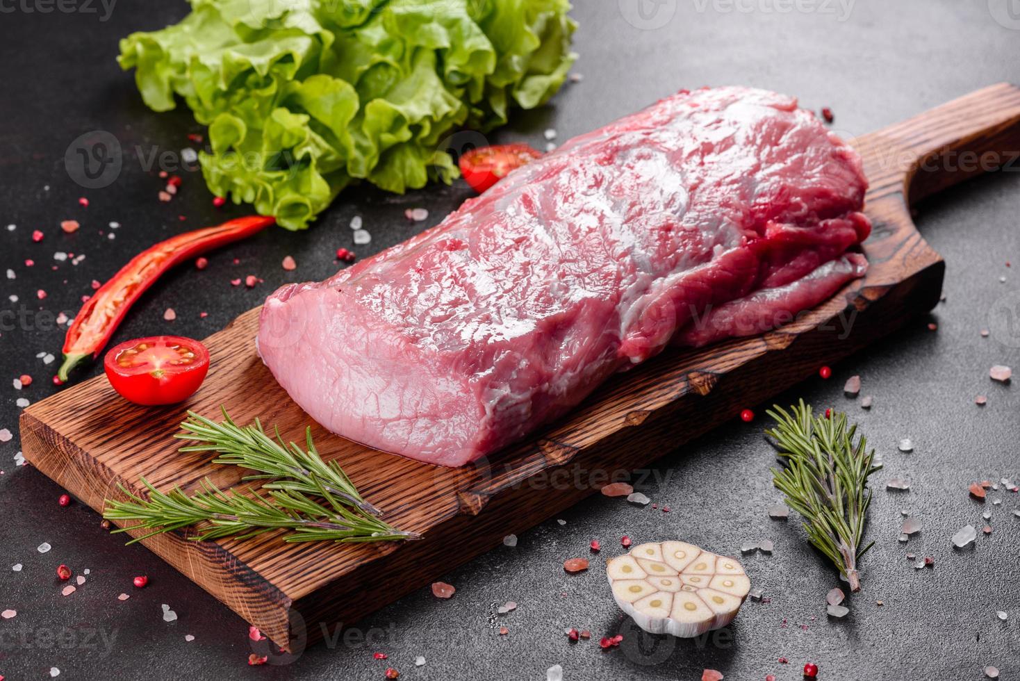 Pedaços frescos de carne de porco pronta para cozinhar em um fundo escuro foto