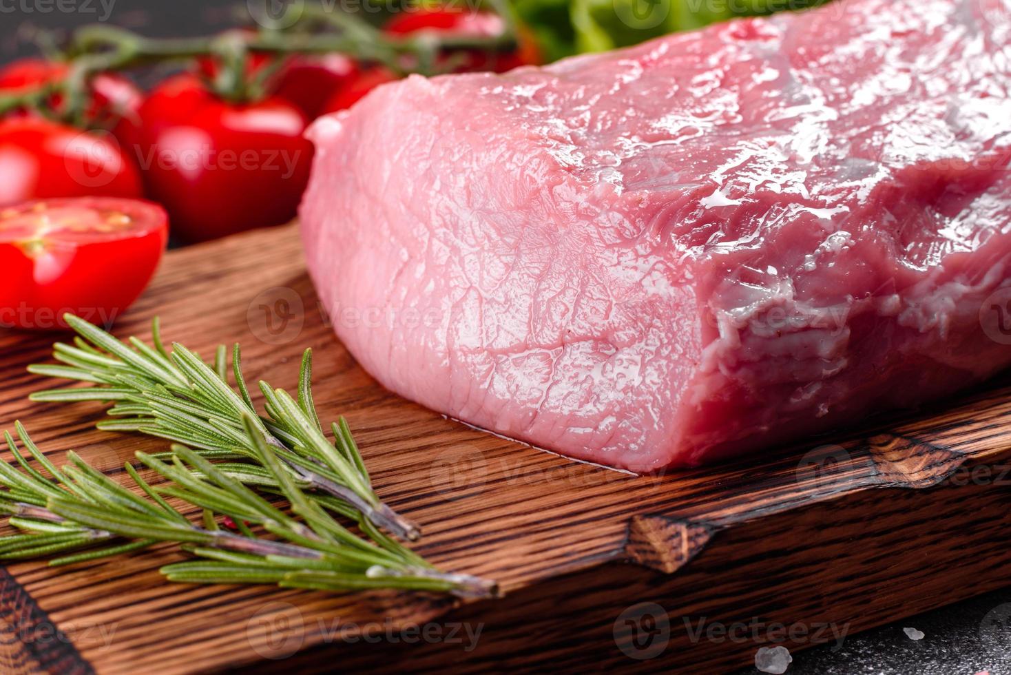 Pedaços frescos de carne de porco pronta para cozinhar em um fundo escuro foto