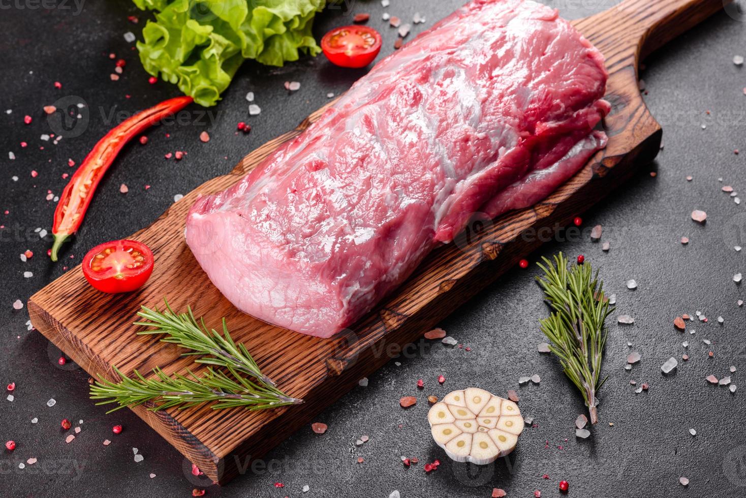 Pedaços frescos de carne de porco pronta para cozinhar em um fundo escuro foto