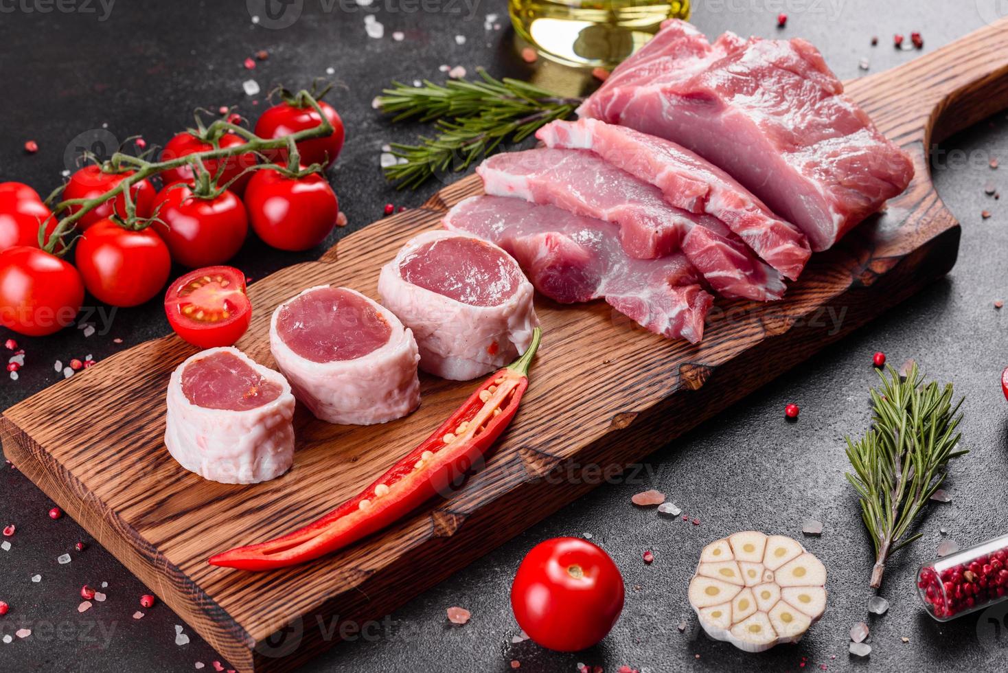 Pedaços de carne de porco prontos para cozinhar em um fundo escuro na cozinha foto