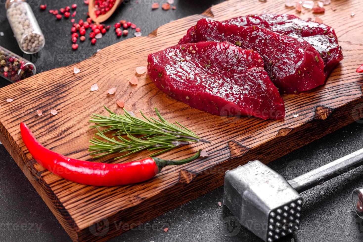bife mignon de carne crua fresca, com sal, pimenta em grão foto