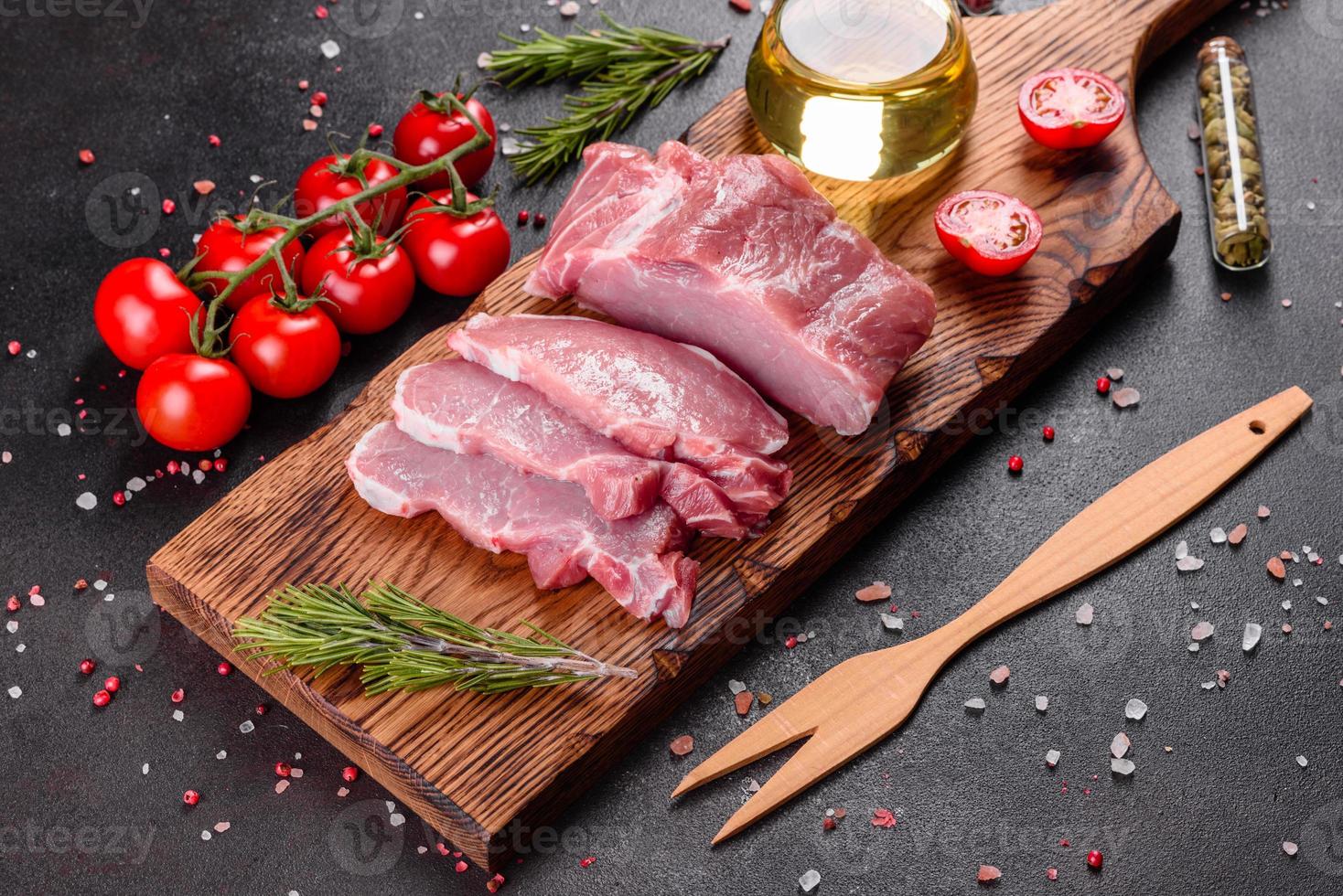 Pedaços de carne de porco prontos para cozinhar em um fundo escuro na cozinha foto