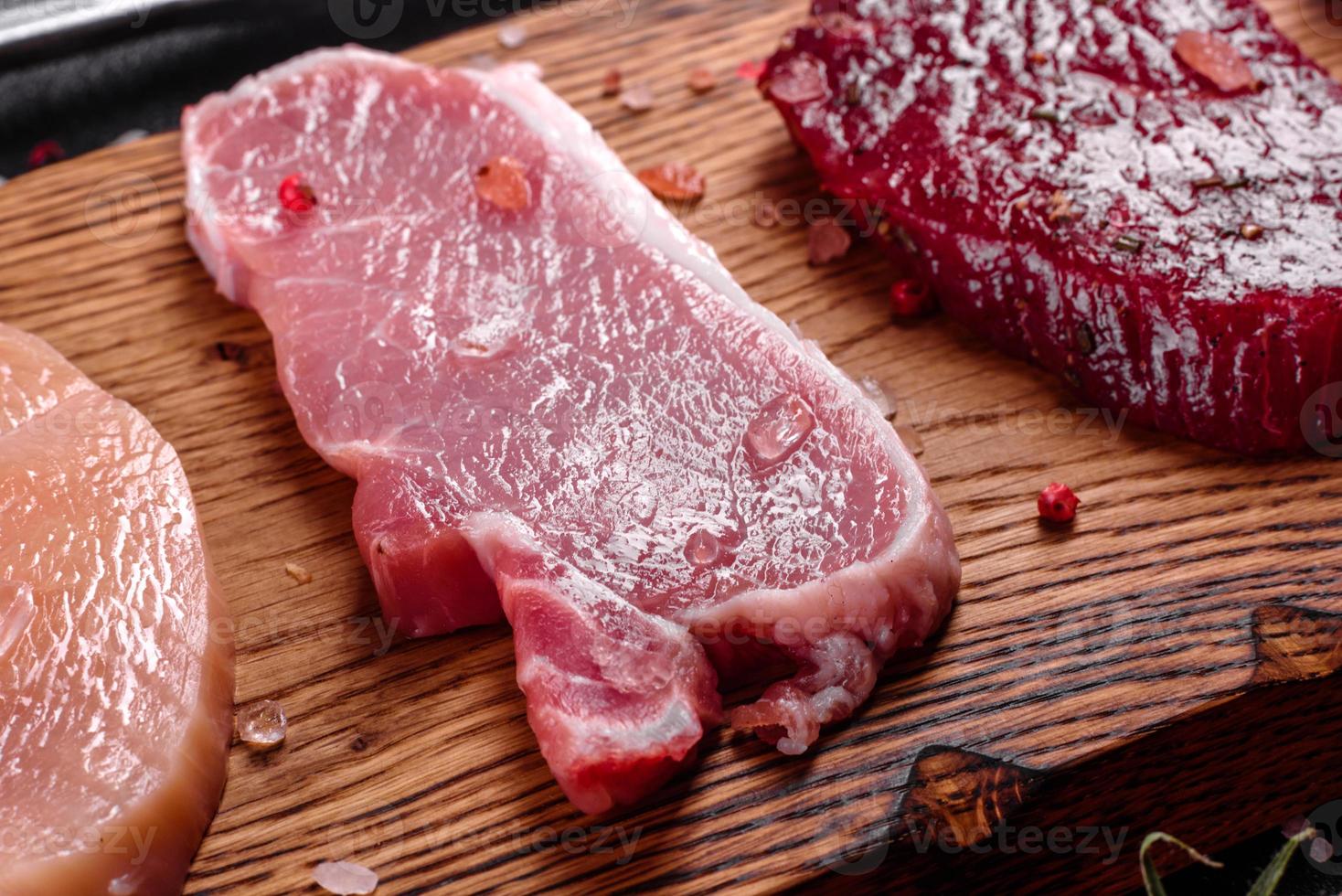 Pedaços de carne de porco prontos para cozinhar em um fundo escuro na cozinha foto