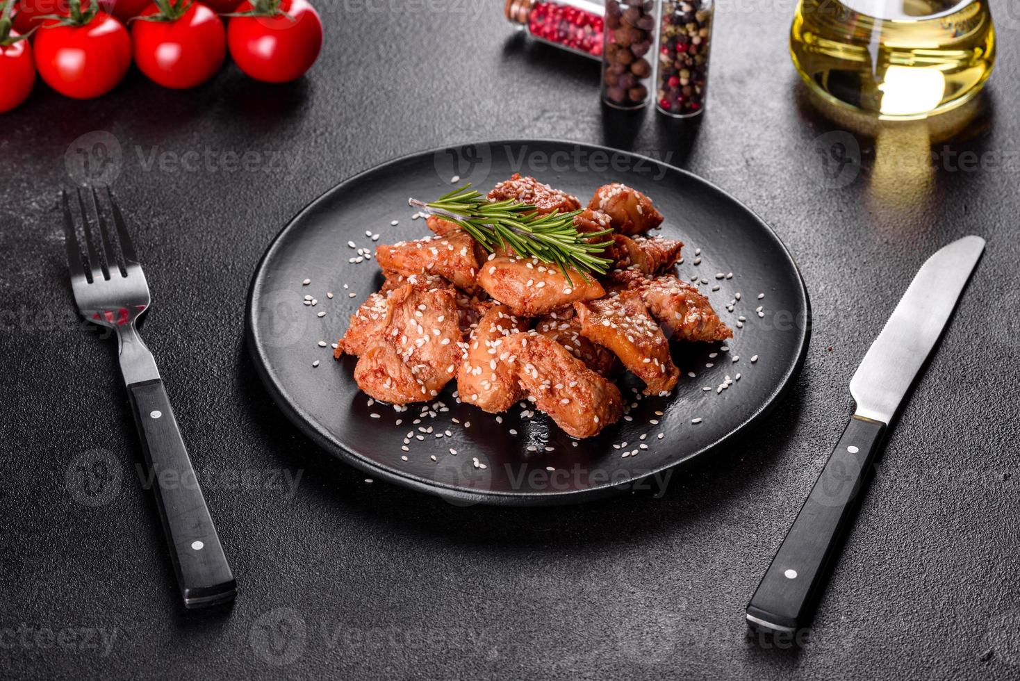 filé de frango em sementes de gergelim, molho teriyaki em um prato de pedra preta foto