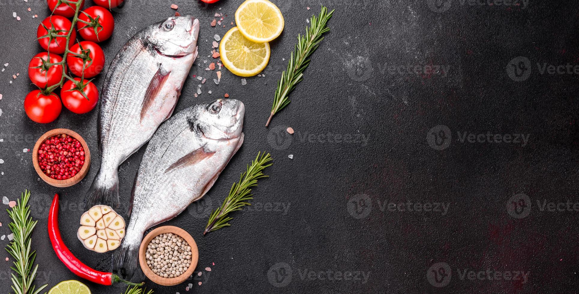 Peixe dourado cru com temperos cozinhando na tábua foto