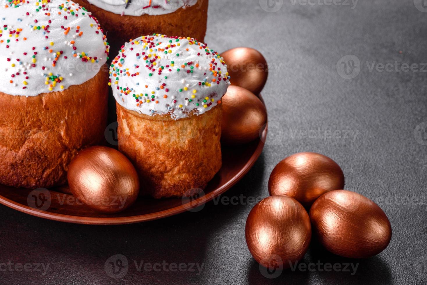 ovos de páscoa ouro e bronze e bolo de páscoa em fundo escuro foto