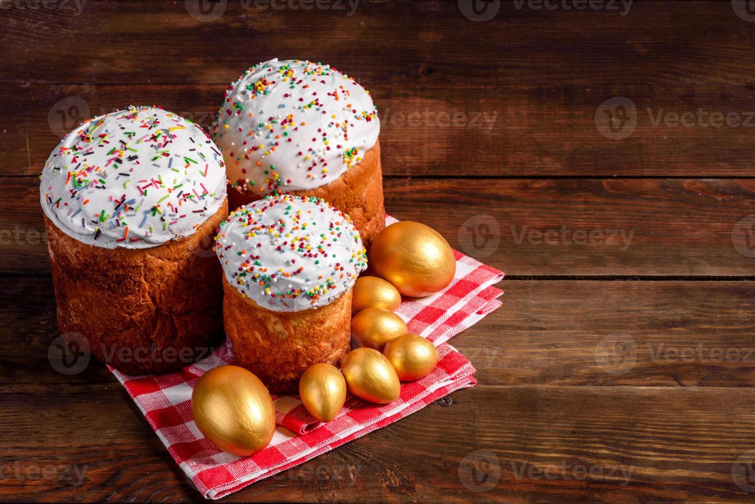 ovos de páscoa ouro e bronze e bolo de páscoa em fundo escuro foto