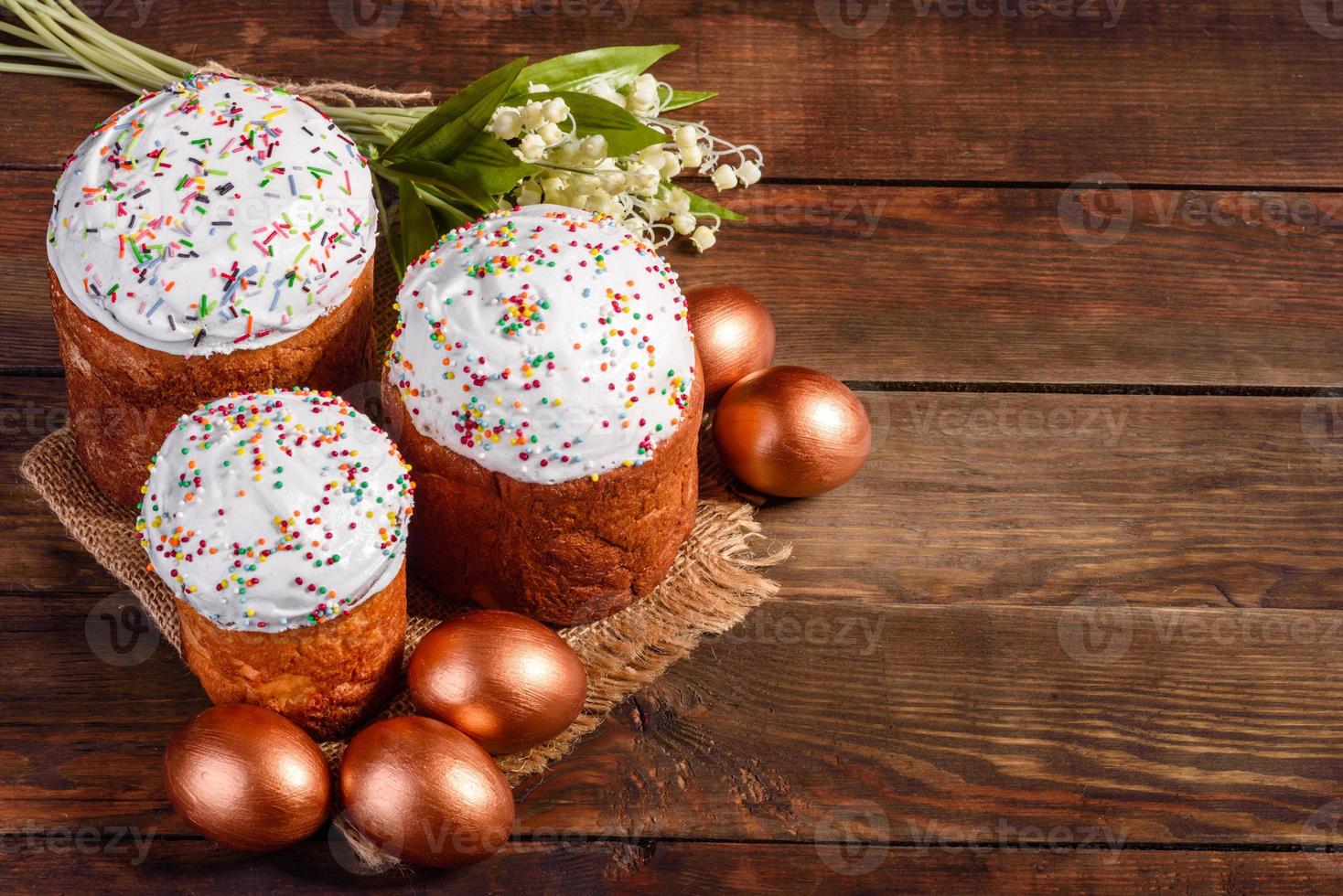 ovos de páscoa ouro e bronze e bolo de páscoa em fundo escuro foto