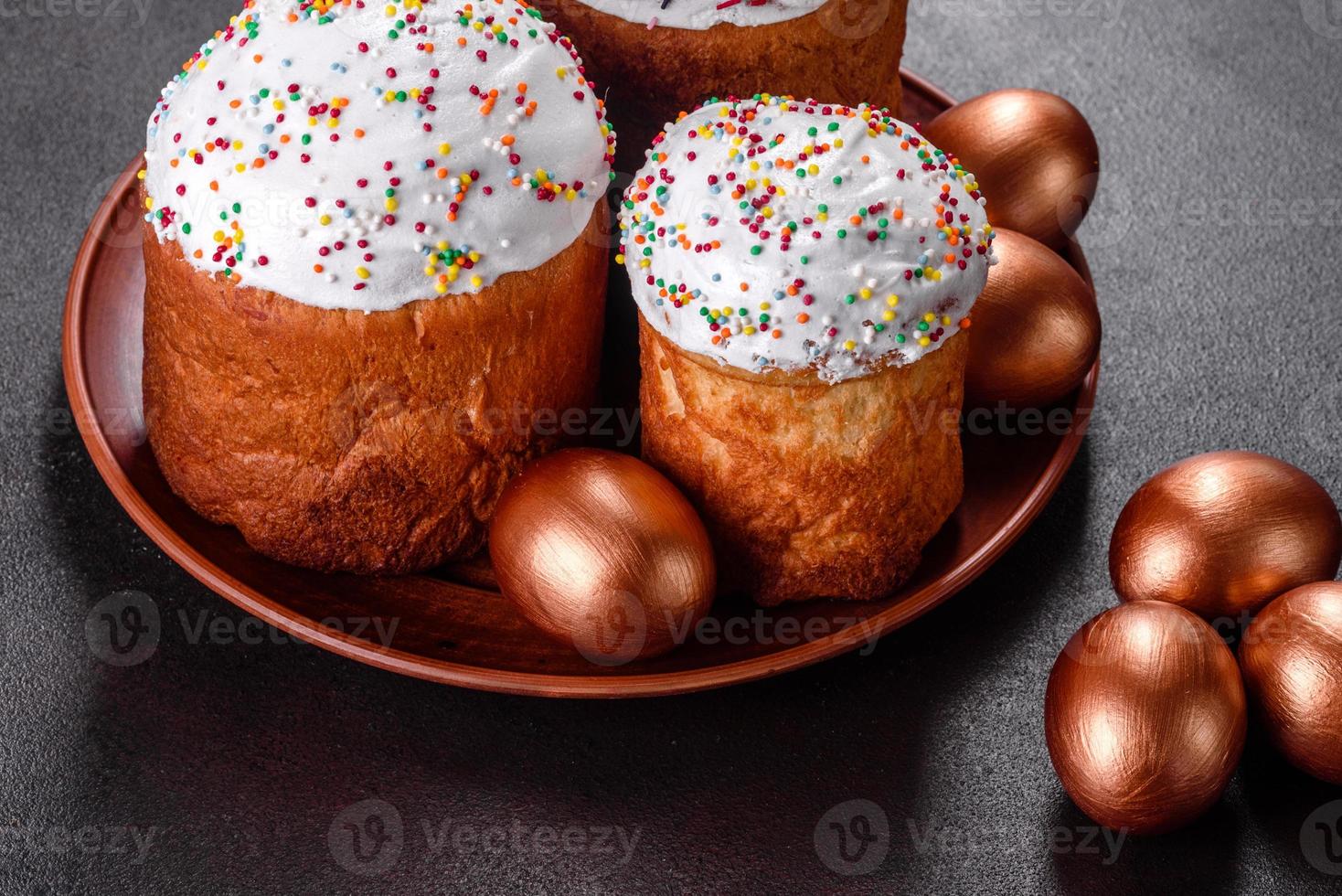 ovos de páscoa ouro e bronze e bolo de páscoa em fundo escuro foto