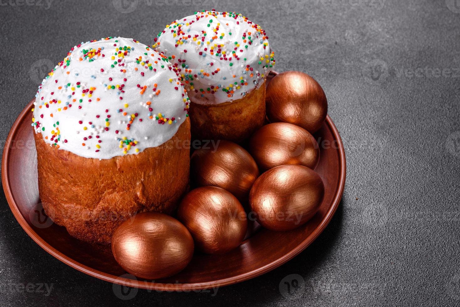 ovos de páscoa ouro e bronze e bolo de páscoa em fundo escuro foto