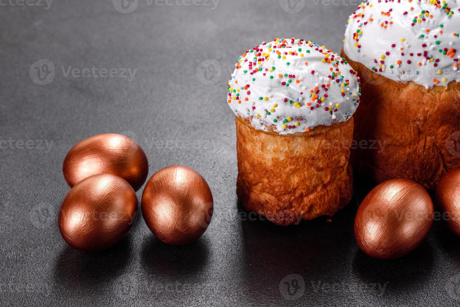 ovos de páscoa ouro e bronze e bolo de páscoa em fundo escuro foto