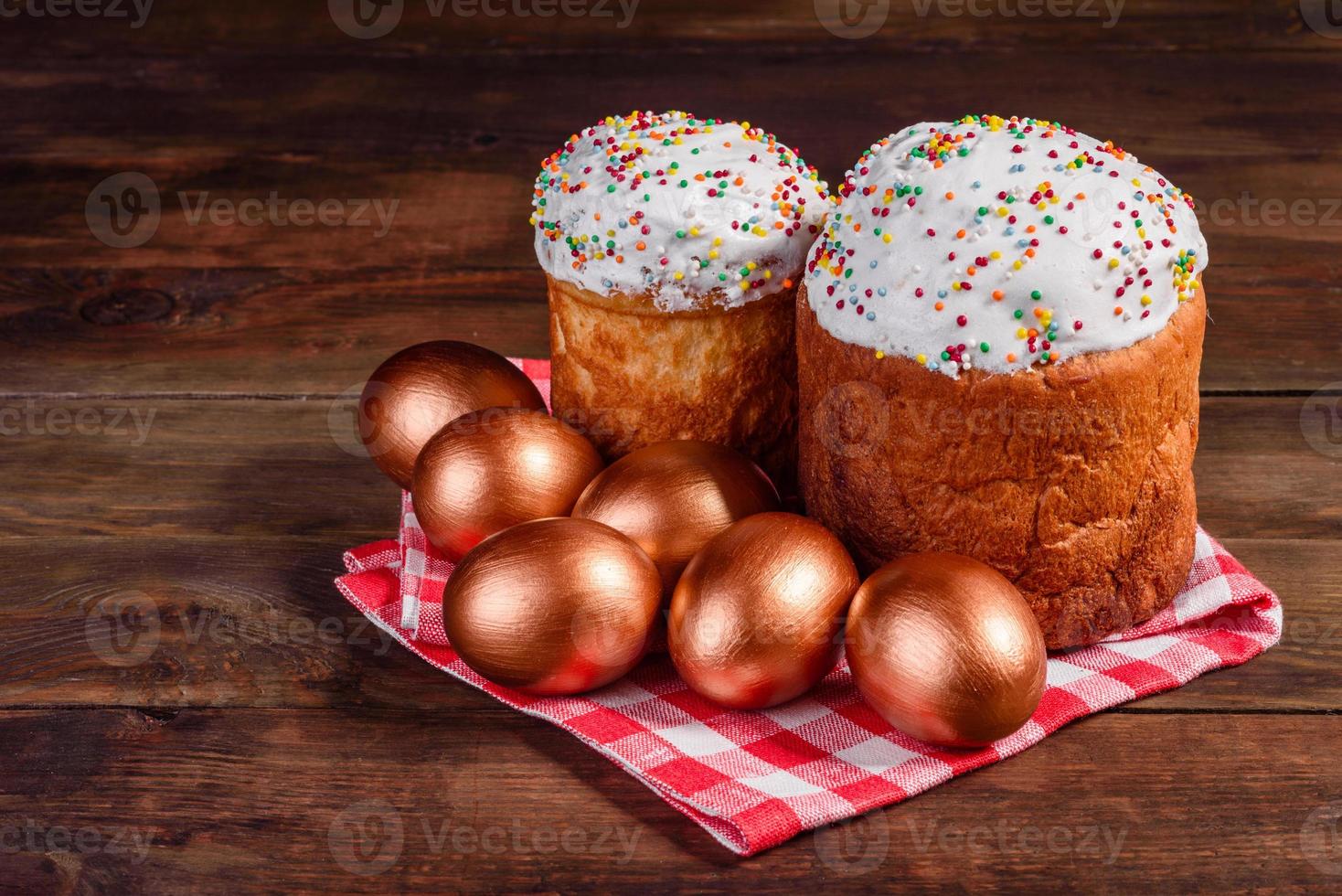 ovos de páscoa ouro e bronze e bolo de páscoa em fundo escuro foto