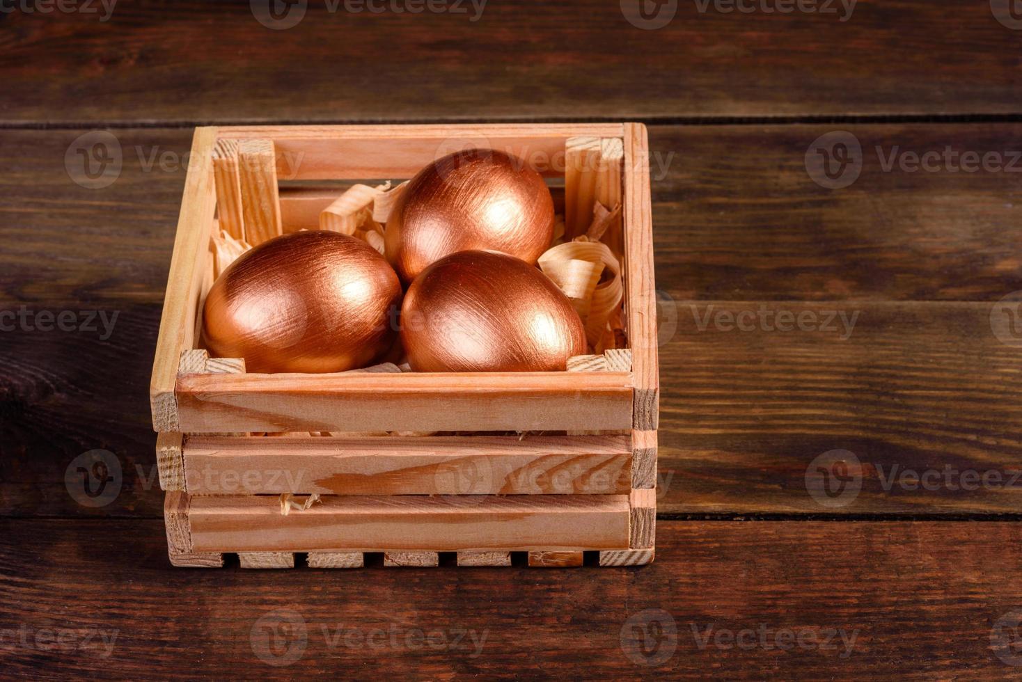 ovos de páscoa em caixa de presente de madeira em fundo escuro de madeira foto