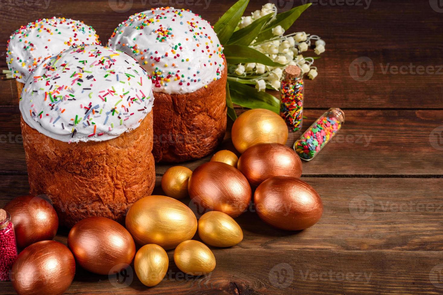 ovos de páscoa ouro e bronze e bolo de páscoa em fundo escuro foto