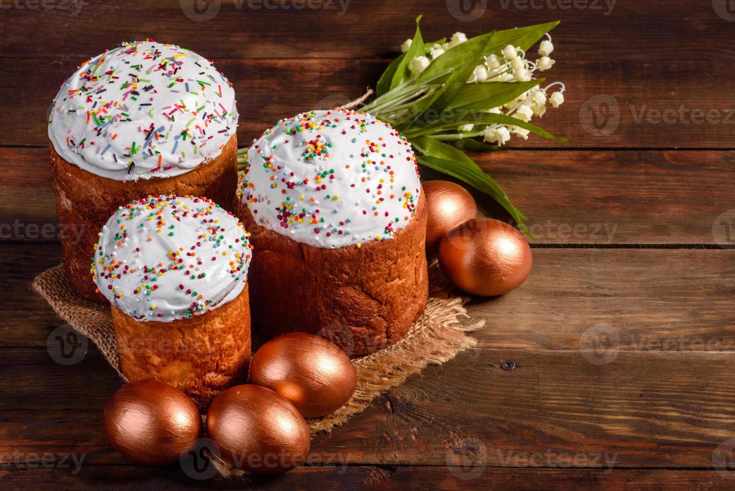 ovos de páscoa ouro e bronze e bolo de páscoa em fundo escuro foto