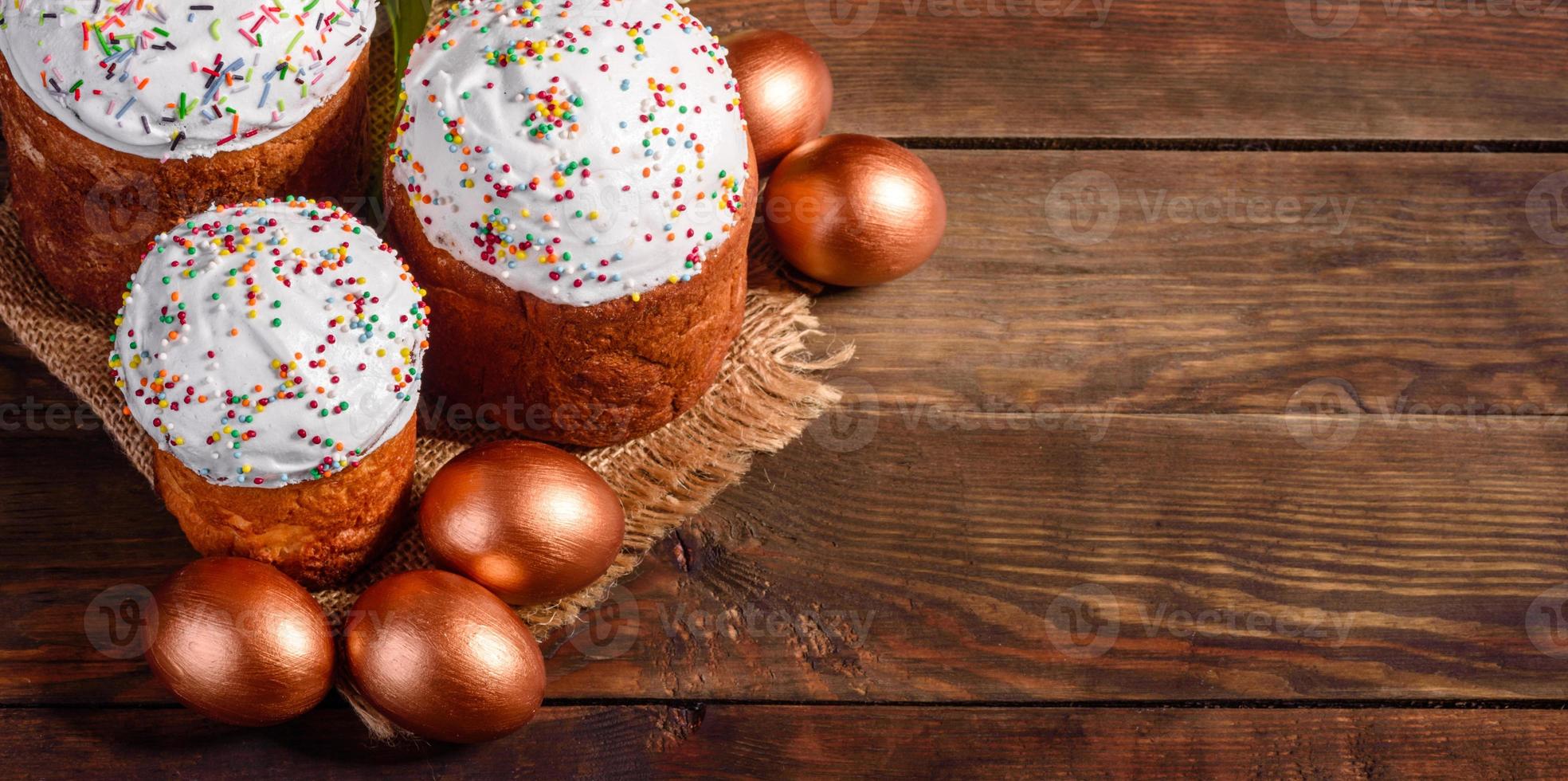 ovos de páscoa ouro e bronze e bolo de páscoa em fundo escuro foto