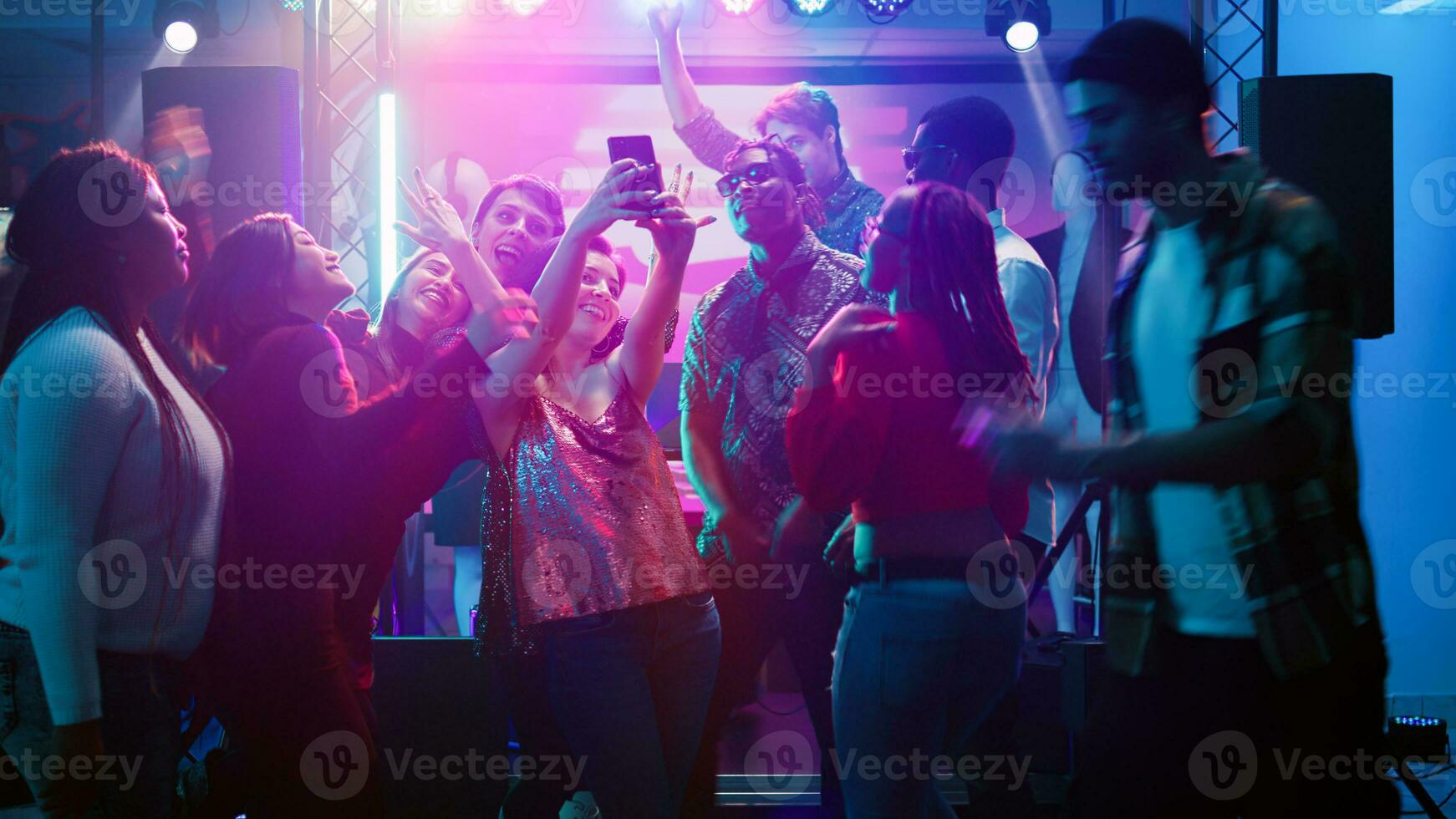 amigos levando As fotos às discoteca festa e tendo Diversão juntos em noite fora, dança evento. grupo do pessoas levando fotos em telefone, fazer Diversão recordações às social celebração. portátil tomada.