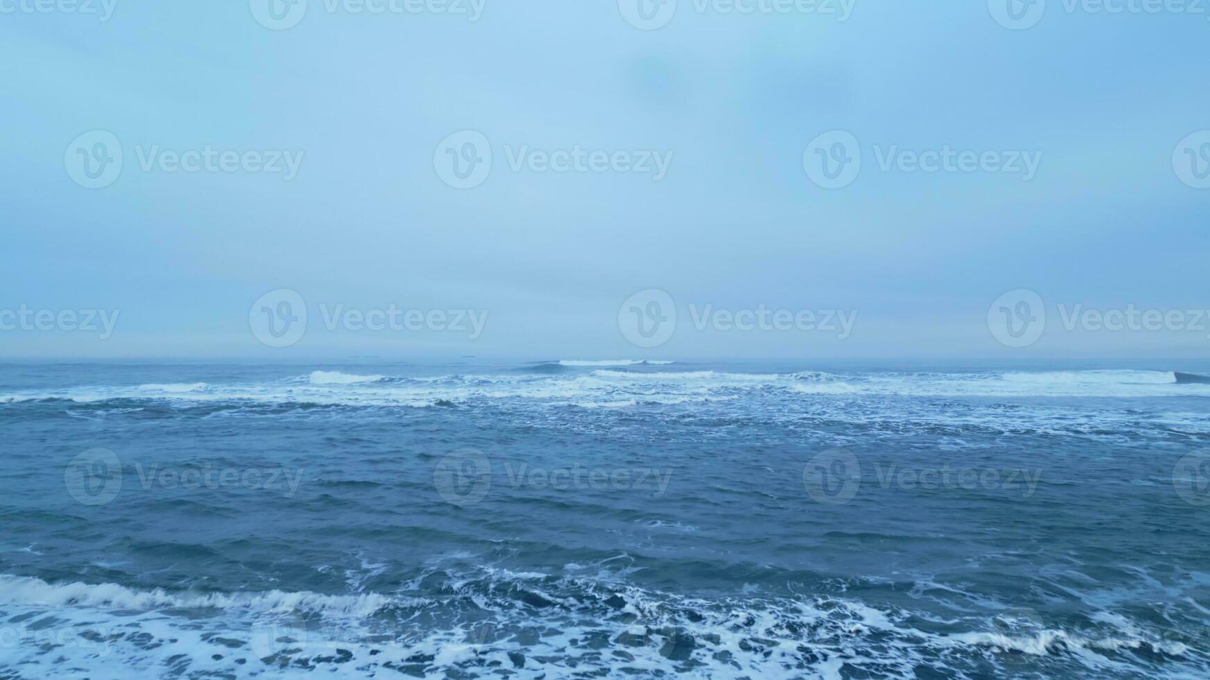 islandês cenário Preto areia de praia com oceano litoral, lindo ártico país com natural panorama. aéreo Visão do Islândia natureza com ondas falhando em atlântico costa. lento movimento. foto