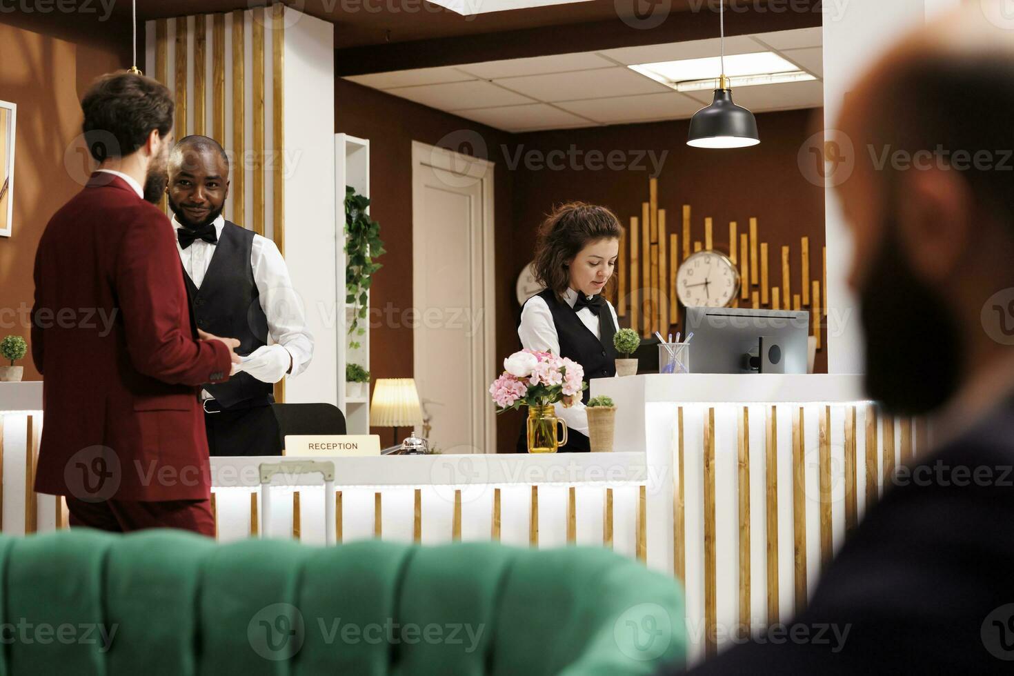 hotel funcionários bem-vinda homem de negocios dentro salão, garantindo desatado e eficiente Verifica dentro experiência. recepcionista partilha luxo recorrer Serviços para Socorro cliente com importante o negócio viagem. foto