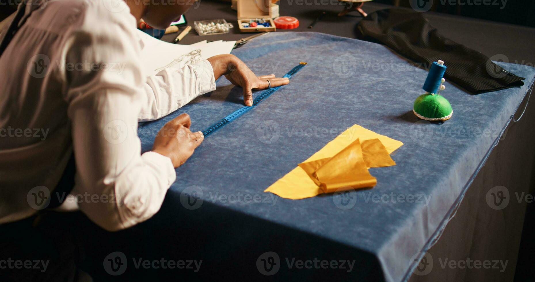 costureiro usando metro dentro ateliê, trabalhando com alfaiataria medindo fita para Verifica tecido dimensões. fêmea desenhador preparando vestuário para Projeto moderno moda Unid, pequeno negócios. foto