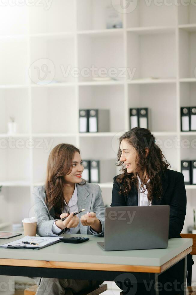 dois empresária discutir investimento projeto trabalhando e planejamento estratégia com tábua computador portátil computador dentro escritório. foto