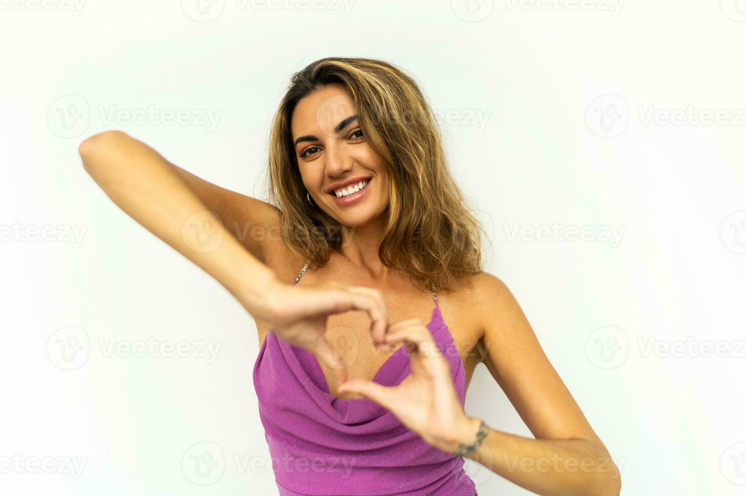 estúdio foto do à moda europeu mulher dentro Rosa vestir e ondulado cabelos posando em branco fundo.