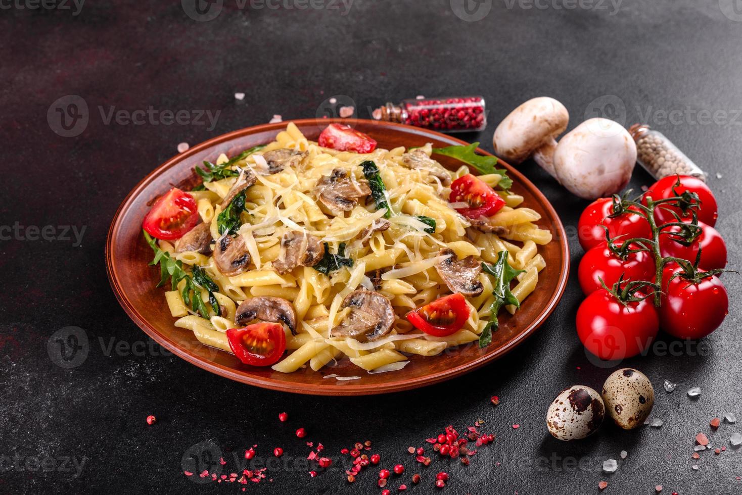 macarrão com cogumelos, queijo, espinafre, rukkola e tomate cereja foto