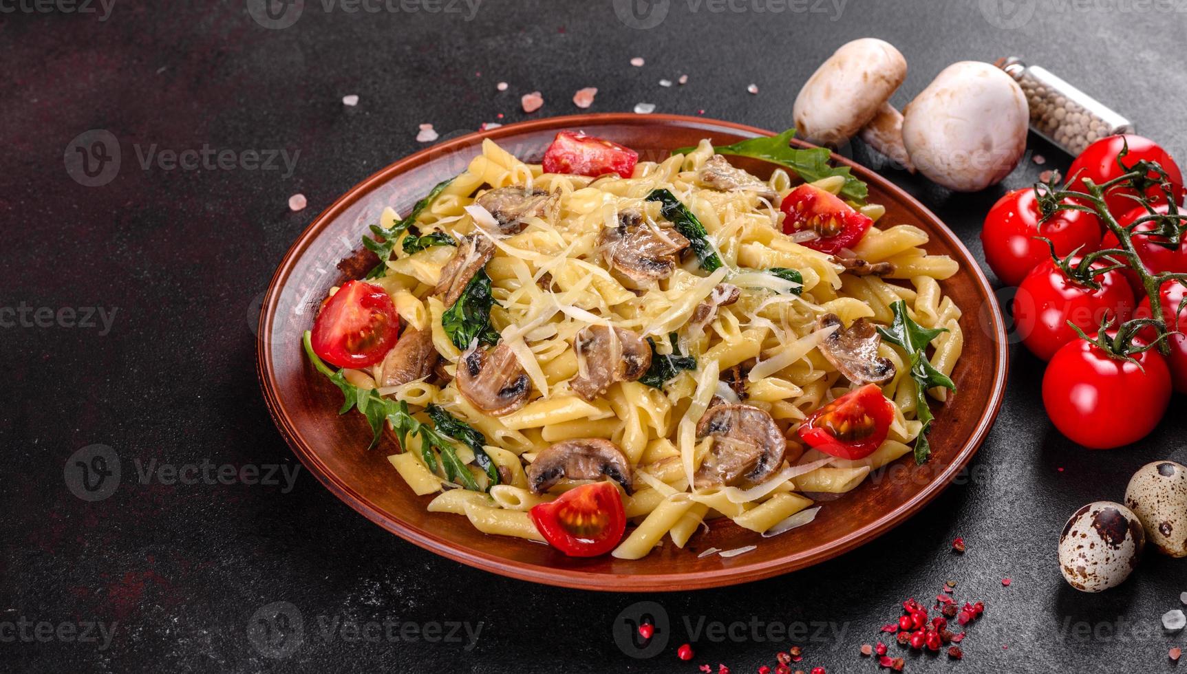 macarrão com cogumelos, queijo, espinafre, rukkola e tomate cereja foto